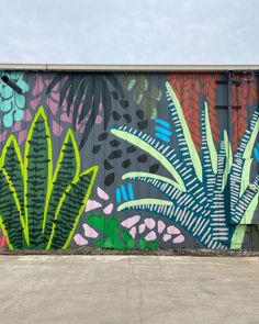 a large mural on the side of a building with plants painted on it's sides