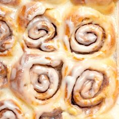 cinnamon rolls with icing sitting in a pan