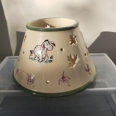 a small white vase with animals painted on it