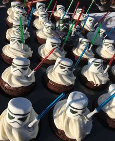 star wars cupcakes with white frosting and straw sticks sticking out of them