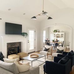 a living room filled with furniture and a flat screen tv mounted on the wall above a fireplace