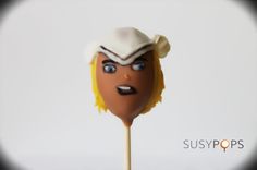 a close up of a cake on a stick with a face painted on it's side