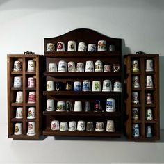 a wooden shelf with many different kinds of cups on it