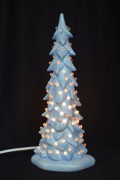 a blue ceramic christmas tree with lights on it