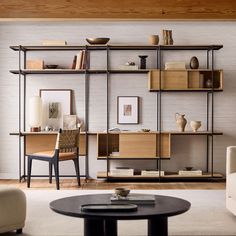 a living room filled with furniture next to a wall mounted book shelf and coffee table