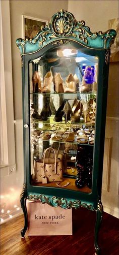 a display case filled with shoes and purses on top of a hard wood floor