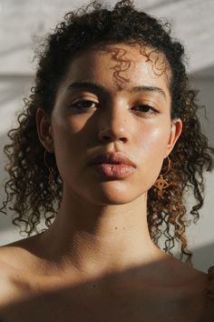 a young woman with curly hair and freckles on her face