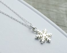 "Our delicate snowflake charm pendant is as unique and beautiful as you. Our snowflake pendant and fine cable necklace chain are 925 sterling silver and both made in Italy. This pendant has been precision cast and then polished. Final pendant thickness is around 2.3mm, which gives the piece substance. We don't Rhodium plate our pieces, as we prefer the brighter shine and color of real silver. Measurements: 16\" and 18\" necklace chain lengths available 0.65\" H (not including ring on necklace) x Ring On Necklace, Winter Bridesmaid Gifts, Winter Wedding Jewelry, Winter Necklace, Sterling Silver Charm Necklace, Snowflake Necklace, Snowflake Pendant, Long Pearl Necklaces, Nature Necklace