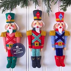 three nutcrackers are hanging on the wall next to a christmas tree branch