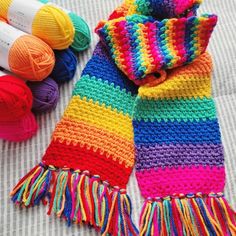 colorful crocheted scarfs and yarn on a bed