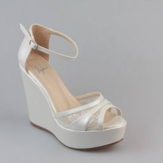 a woman's white wedged shoe with an open toe and lace detailing on the platform