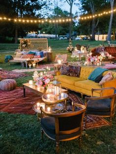 an outdoor seating area is lit up with string lights and decorated in pink, blue, yellow and green