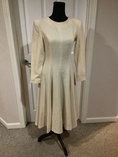 This nice vintage Vogue 50s 60s cream bone Pollyanna padded shoulder full romantic dress with huge bow in back comes to you in a size S-M. As you can see nice vintage cond. there are a couple of tiny pin prick holes one up by shoulder pictured and one on sleeve. Pretty typical age. Timeless flattering style. Waist is 14 inches across-21 1/2 inches shoulder to bottom of arm. 43 inches shoulder to bottom of dress. Full skirt style. Very figure flattering Elegant Beige A-line Vintage Dress, Fitted A-line Dress With Button Back, 1950s Style A-line Midi Dress For Formal Occasions, Beige A-line Midi Dress For Wedding, Elegant A-line Midi Dress For Vintage Fashion, Classic A-line Vintage Wedding Dress, Cream A-line Winter Dress, Fitted A-line Vintage Dress For Winter, Chic Beige Vintage Midi Dress