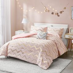 a bedroom with pink walls and white bedding in the center is decorated with string lights