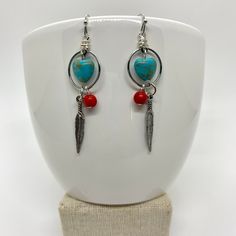 These look a little southwestern to me. I love turquoise, silver, and coral colors together. I grew up in South Dakota, so these remind me of home.  ♥ Materials used: - silver hoop earrings - turquoise magnesite heart beads - red coral howlite beads - silver feather charms ♥ CARING FOR YOUR JEWELRY Gently wipe your jewelry with a soft cloth to remove sweat, perfume, excess oils or dirt before putting them away. All of these products are handmade by me with care and attention to detail in a clean, smoke-free environment. I am happy to answer any questions you may have about any of my products. I also do custom orders, so please feel free to contact me with a design you have in mind. I will get back to you ASAP. Ships fast and free! Order today, ships next business day featuring USPS first c Nickel-free Red Southwestern Earrings, Nickel-free Southwestern Red Earrings, Handmade Bohemian Sterling Silver Heart Earrings, Bohemian Handmade Sterling Silver Heart Earrings, Southwestern Style Red Nickel-free Earrings, Bohemian Nickel-free Heart Earrings, Bohemian Sterling Silver Heart Earrings, Handmade Heart-shaped Sterling Silver Hoop Earrings, Southwestern Dangle Hoop Earrings As Gift