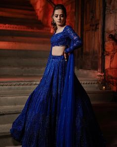 The lehenga features all over sequin, crystal, cutdana and crystal embroidery. Paired with a statement full sleeves blouse with dangling tassel detailing at the back and attached one shoulder drape.DELIVERY TIMEPlease allow 8-12 weeks for your outfit to arrive.FABRIC DETAILSNetProfessional cleaning only. Engagement Lehenga Bridal Collection, Electric Blue Lehenga, Crystal Lehenga, Drape Dupatta, Full Sleeves Blouse, Lehenga Blue, Royal Blue Lehenga, Lehenga Ideas, Long Skirt Top Designs