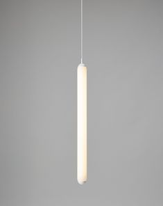 a white light hanging from a ceiling in a room with gray walls and flooring