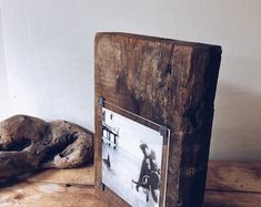 an old photo frame sitting on top of a wooden table next to a stuffed animal