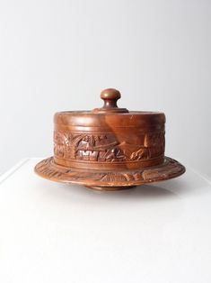 a wooden container with a lid sitting on top of a white table next to a wall