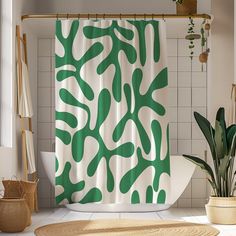 a green and white shower curtain hanging on a wall next to a potted plant