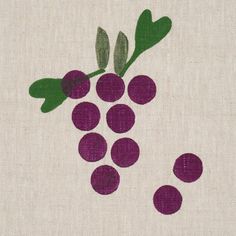 a close up of a piece of cloth with grapes on it and leaves in the middle