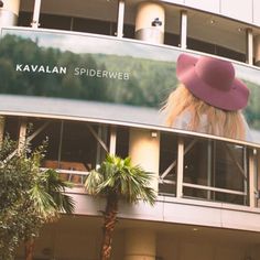 a woman wearing a pink hat in front of a building