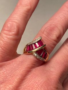 "Stunning art deco 14K synthetic Ruby and natural earth-mined Diamond Bypass wide band Ring. the ring is a size 6.5 and weighs 5 grams. The face measures 5/8\" tall at the widest measurement. Nine 5mm x 3mm tapered baguette rubies in open back channel setting with eight pave set round cut diamonds. Marked 14K, GA. Excellent condition. The stones are an intense red to fuchsia." Elegant Luxury Baguette-cut Ruby Ring, Heart Piercing, Dagger Earrings, Gold Jewellry, Diamond Baguette, Wide Band Ring, Channel Setting, Wide Band Rings, Natural Earth