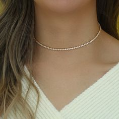 Introducing the Cristal Choker, a dazzling and sophisticated accessory that is sure to turn heads. This stunning choker features a beautiful Cristal Rhinestone design, which adds a touch of glamour and elegance to any outfit. Crafted with high-quality materials, this choker is made with stainless steel and plated with 14k gold, giving it a beautiful and long-lasting shine. Its tarnish and water-resistant properties make it the perfect accessory for daily wear, ensuring that it will maintain its Dazzling Crystal Necklaces For Formal Occasions, Dazzling Diamond Necklace With Clavicle Chain For Party, Sparkling Cubic Zirconia Choker Necklace, Elegant Rose Gold Crystal Necklaces For Party, Elegant Rose Gold Crystal Necklace For Parties, Elegant Sparkling Jewelry Choker, Diamond White Necklaces For Party, Diamond White Diamond Necklace With Rhinestones, Elegant Tennis Choker Necklace For Party