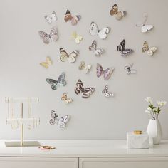 there are many butterflies on the wall and one is white with gold trimmings