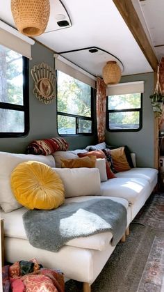 a living room filled with lots of furniture and pillows on top of it's couches