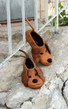 two slippers made to look like dogs are sitting on the ground next to a gate