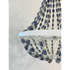 a chandelier with blue and white beads hanging from it's ceiling fixture