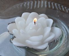 a lit candle in a glass bowl with water