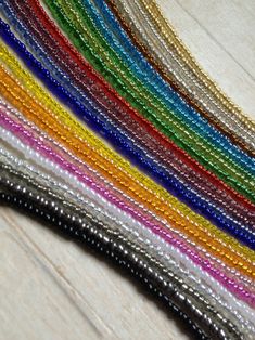 many different colored beads on a wooden surface