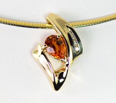 A fiery tangerine Spessartite Mandarin Garnet is accented with four graduated Diamonds in a pendant slide in 14k yellow gold. Spessartite, a rare form of garnet, also called mandarin or Malaya garnet, ranges from a yellow-orange through brilliant orange to orange-red. They combine very good hardness with excellent brilliance and sparkle. Spessartite are from Africa and are completely natural. Garnet is January's birthstone and the 2nd wedding anniversary gemstone. Metal: 14k yellow Gold The spes Orange Diamond Accented Jewelry For Weddings, Orange Diamond Jewelry With Diamond Accents, Luxury Orange Gemstone Accented Jewelry, Luxury Orange Jewelry With Gemstone Accents, Luxury Orange Gemstone Jewelry, Formal Orange Jewelry With Accent Stones, Elegant Orange Jewelry With Diamond Accents, Orange Polished Wedding Jewelry, Orange Polished Finish Wedding Jewelry