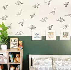 a bedroom with dinosaur wall decals on the walls and bed in front of it