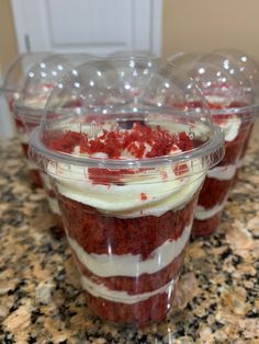 three plastic cups filled with food on top of a counter