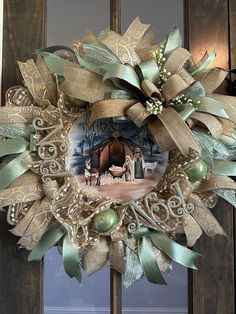 a wreath is hanging on the front door with an image of jesus and baby jesus