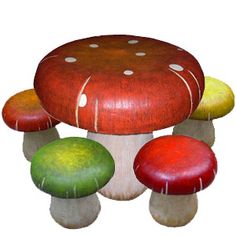 three different colored mushrooms with white spots on them and one red mushroom is in the middle