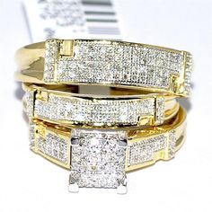 three gold rings with white diamonds on top of each other and one has a price tag in the background