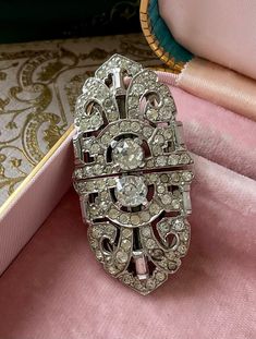 The 1940 art deco rhinestone duette brooch is a radiant testament to vintage glamour. Adorned with baguette and round clear crystals, it exudes timeless elegance. Every stone gleams brightly, reflecting the era's opulence. This versatile piece showcases the duette's unique feature, allowing it to transform into dress or shoe clips, offering varied styling options beyond its traditional brooch function. With no missing stones, it maintains its original allure. Measuring 2-1/2 inches in width and Vintage White Gold Brooches For Wedding, Art Deco Diamond Jewelry For Evening, Art Deco Diamond Evening Jewelry, Vintage White Gold Brooches With Diamond Accents, Elegant Silver Brooches For Vintage Events, Art Deco White Gold Brooch Jewelry, Art Deco Diamond Brooch Jewelry, Art Deco Jewelry With Diamond Accents For Evening, Victorian Rhinestone Jewelry For Anniversary