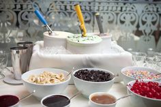 a table topped with bowls filled with different types of desserts and condiments