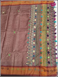 an old cloth with many different designs and colors on it's sides, including some beads