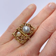 "1970s Unisex Brutalist Unique Pearl Ring in Gold.  A custom made artisan unisex pearl ring in solid 14K yellow gold and set with two baroque salt water pearls.  This pearl gold ring dates to the 1970s and is in lovely condition ready to gift or to wear.  The design is one of a kind and it is completely handmade with no cast or machined components.  It is a big ring with the top of the ring measuring 13/16\" long by 11/16\" wide by 9/16\" tall (21mm x 18mm x 15mm).  In total it weighs 9 grams. O Modernist Gold Wedding Rings, Modernist Gold Jewelry For Wedding, Modernist Gold Wedding Jewelry, Heirloom Style Gold Pearl Open Ring, Heirloom Gold Pearl Open Ring, Handmade 14k Gold Pearl Ring, Unique 14k Yellow Gold Pearl Ring, Unique Yellow Gold Pearl Ring For Anniversary, Unique Gold Oval Pearl Ring