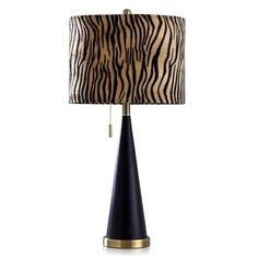 a black and gold lamp with a zebra print shade on the top, sitting on a white background