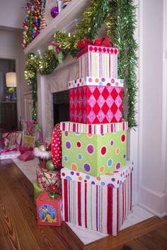 christmas presents stacked on top of each other in front of a fireplace