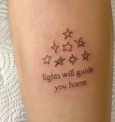 a tattoo saying lights will guide you home on someone's leg with five stars