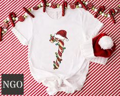 Christmas Candy Cane Tshirt, Candy Cane Crew Shirts, Christmas Matching Shirt, Funny Holiday Tshirt, Family Matching Shirt, Christmas Gifts ---HOW TO ORDER--- 1-) Please, check and review all photos 2-) Choose your t-shirt size and color *Different styles of shirts may have different shades of same color choice due to different manufacturer brands. *For this reason, we recommend you to match shirts from the same styles if you want precisely matching colors (exa. Unisex,V-neck, Tank top, etc.). 3-) Click add to cart. You can go back to add more product 4-)Click "Proceed to check out" 5-)When you check out, you can add a note to seller for any request ---We make DTF printing--- Dtf prints are not only charming and durable, but they also resist fading, cracking, and peeling. With advanced tec White Christmas T-shirt Gift, White Holiday T-shirt Gift, White Holiday Gift T-shirt, White T-shirt For Holiday Gift, White T-shirt As Holiday Gift, Christmas Matching, Funny Holiday, Dtf Printing, Matching Colors