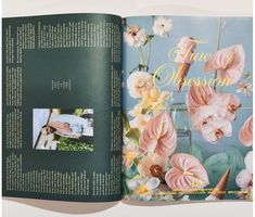 an open book with pink flowers on the cover and photos inside it, in front of a white background