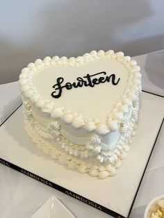 a heart - shaped cake with the name jeanette on it sits on a table